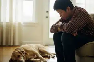 Quand s'inquiéter pour son chien : une personne observe avec inquiétude son chien allongé